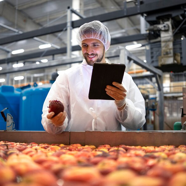Person in a food processing plant using a tablet device.